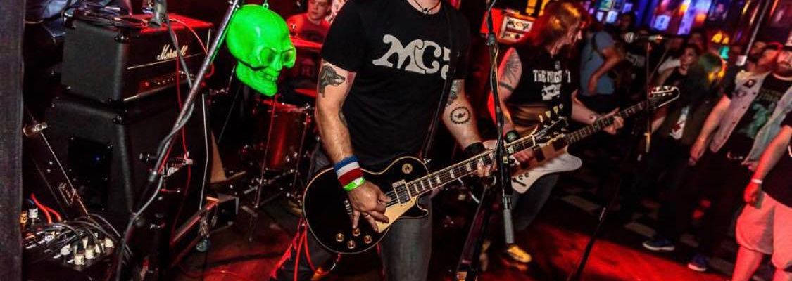 Tommy Erickson ofSlumlord Radio singing and playing guitar on stage